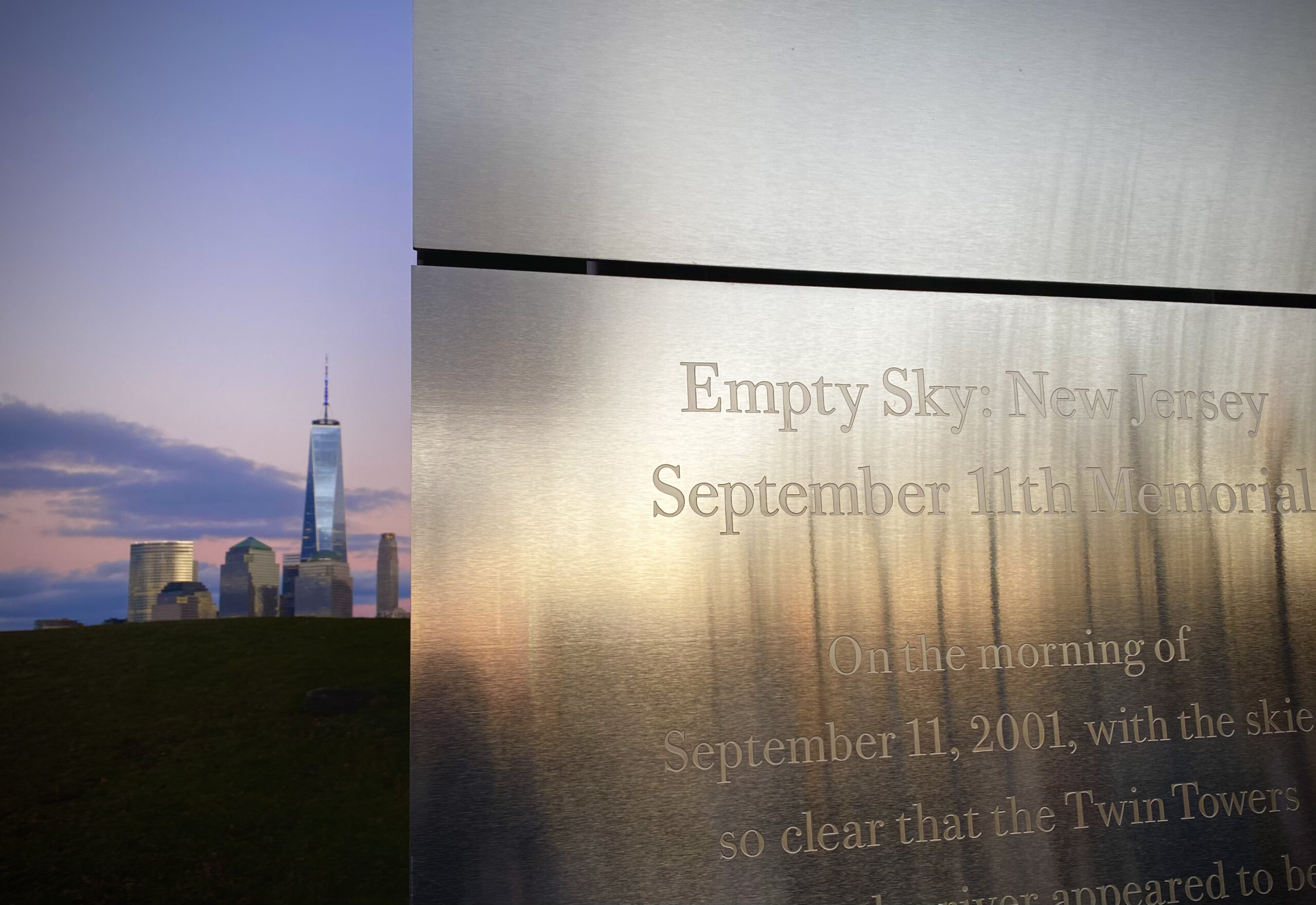 In the foreground on the right is a memorial for 9-11 and on the left is Freedom Tower and a beautiful sunset. 