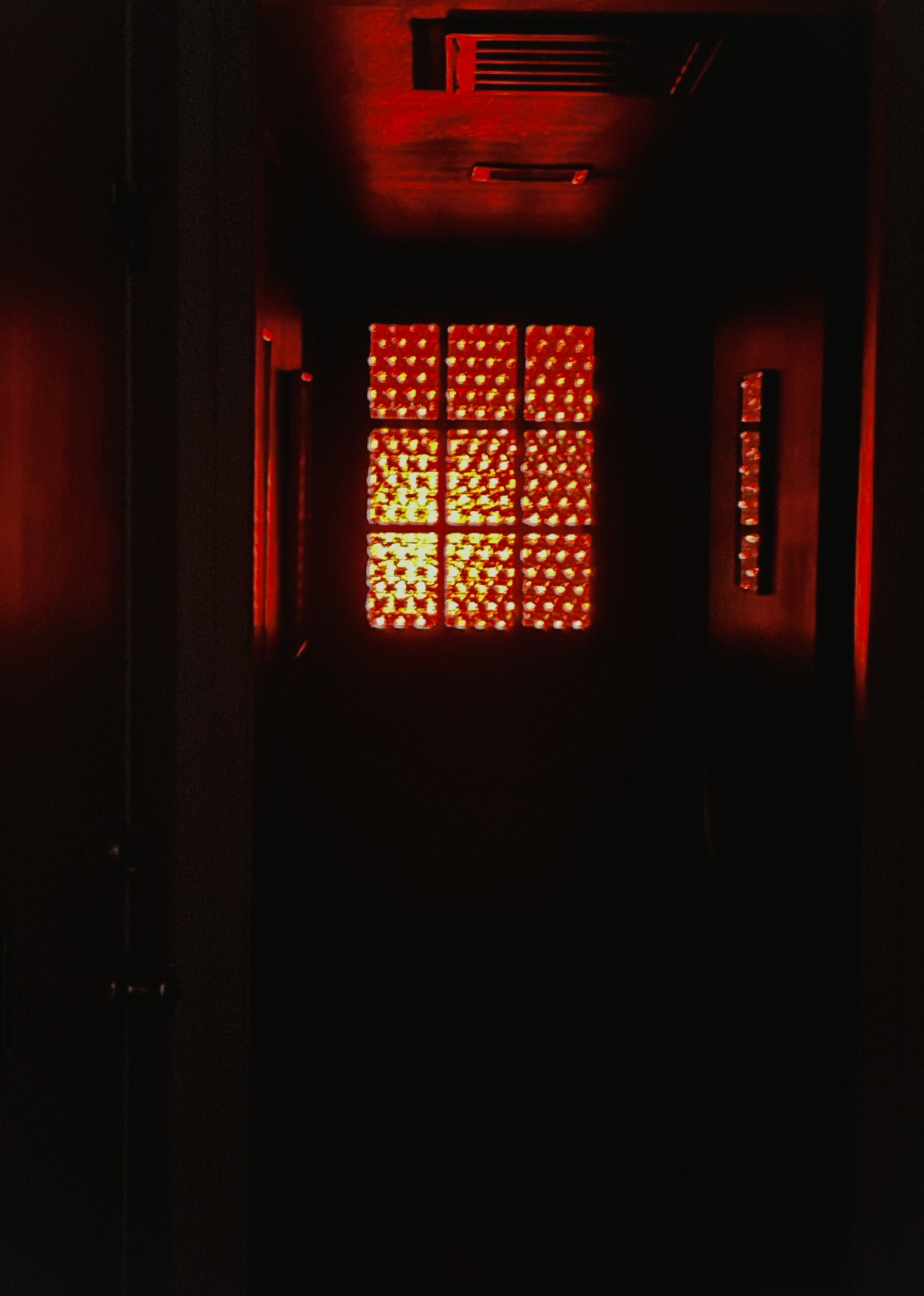 A red door with walls shining in red light. 