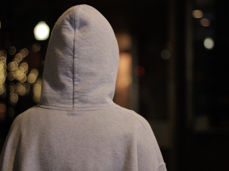 A highschool student takes a leisure walk downtown after smoking