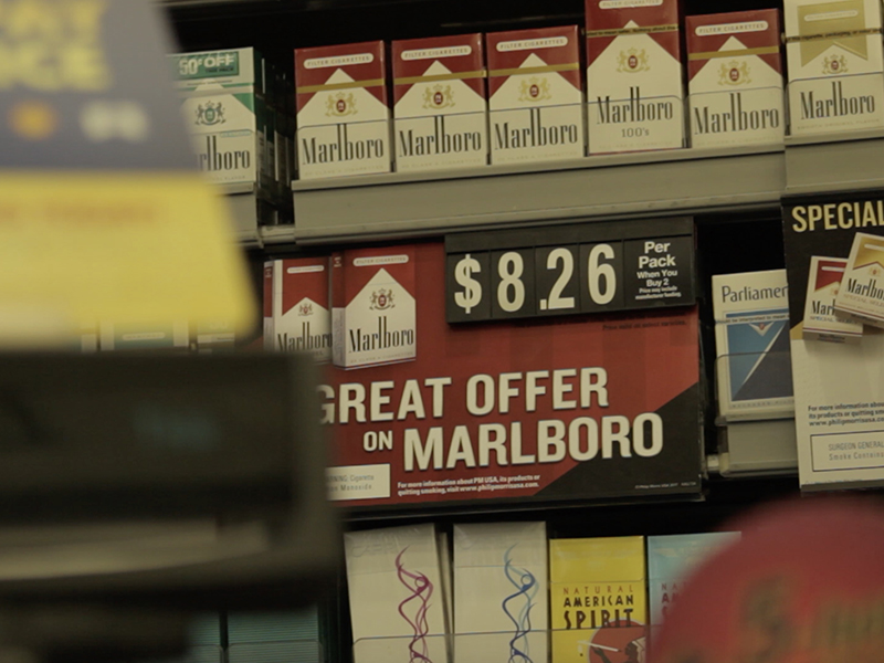 Cigarette packs being sold behind a gas station counter