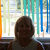 Carol sitting in front of rainbow streamers at LAUMC
