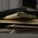 A messy stack of my sketchbooks to show who I am.