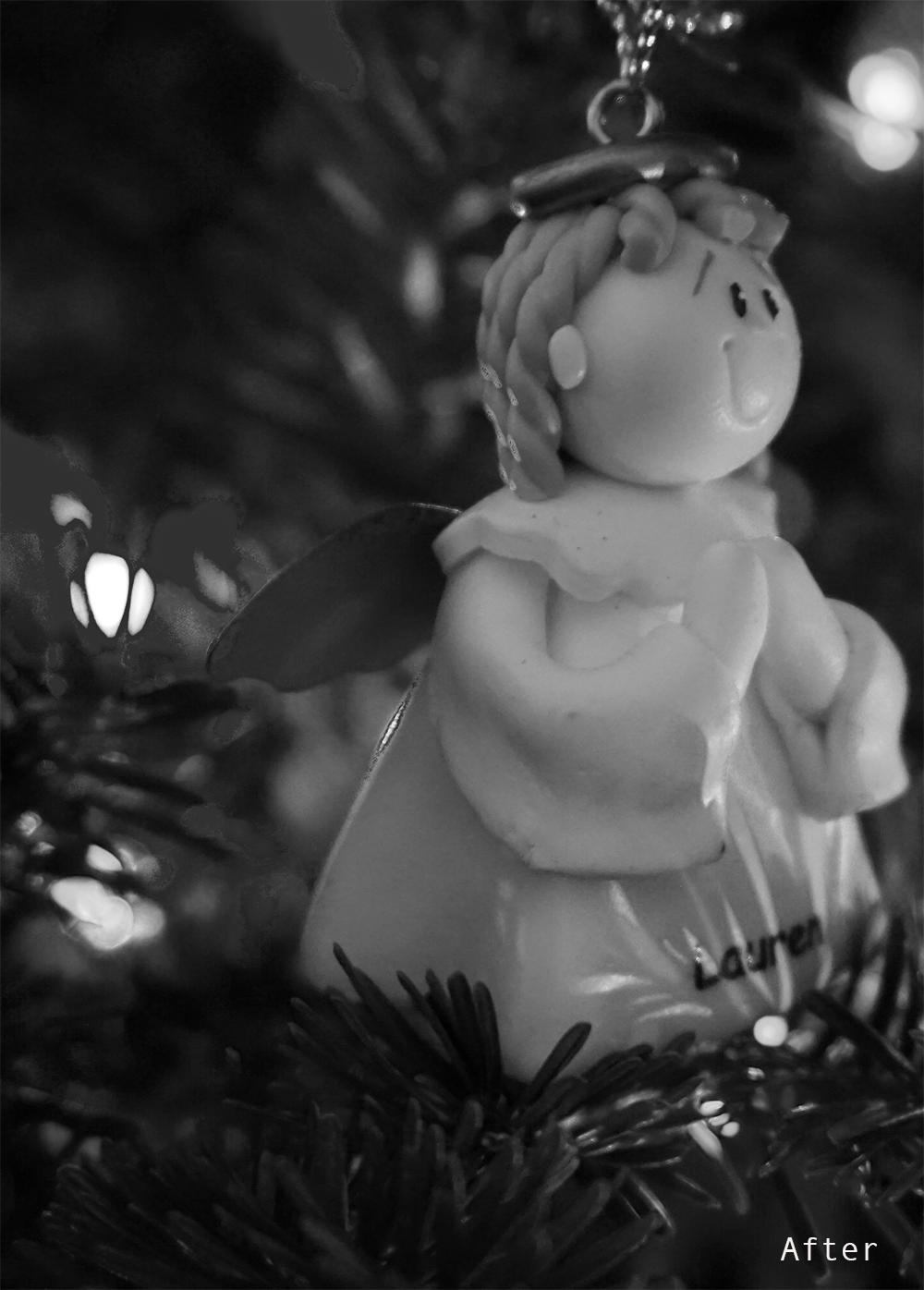a christmas angel ornament in a tree in black and white
