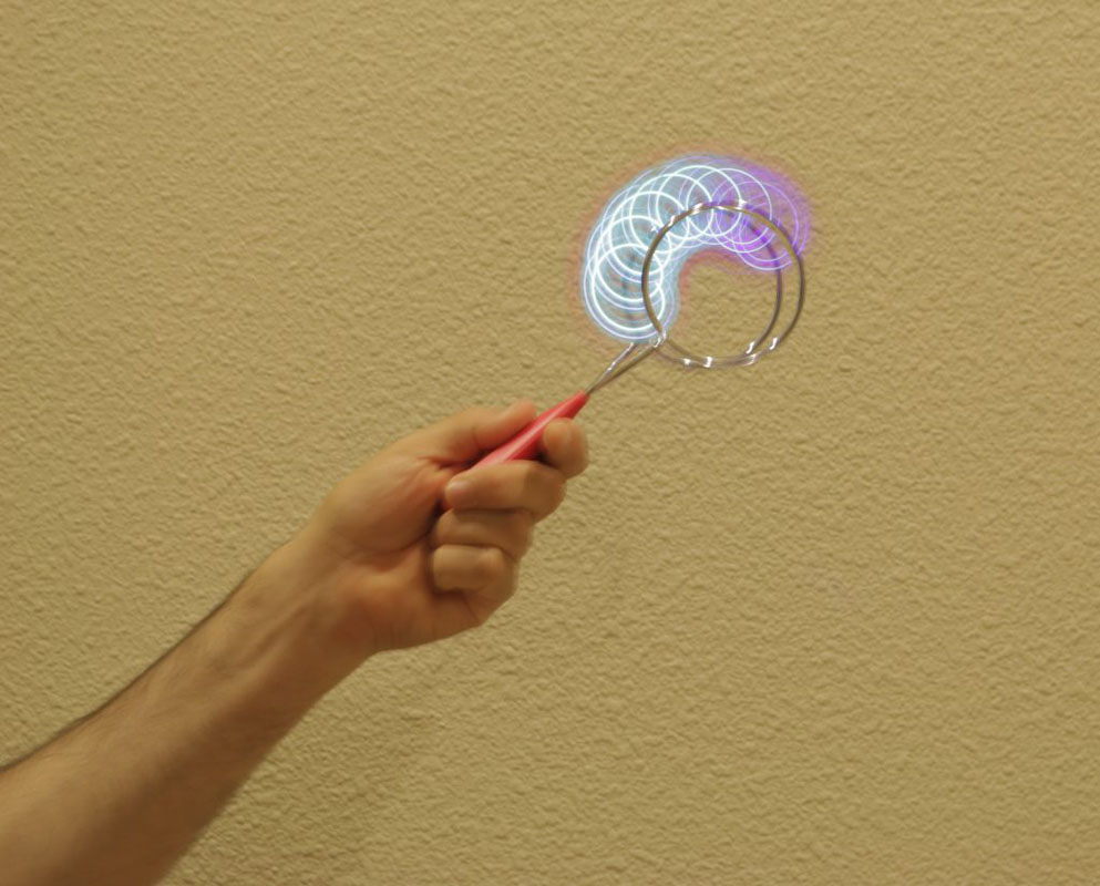 A hand holding a toy that's lighting up and spinning.