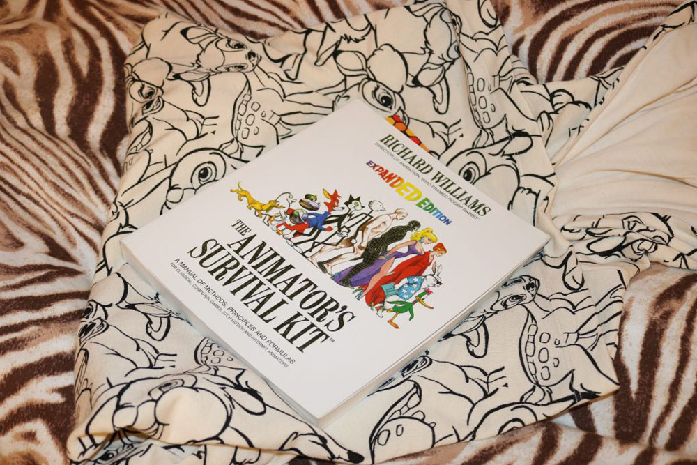 A book by Richard Williams, titled "The Animator's Survival Kit", on top of a Disney's Bambi hoodie sitting on the back of a zebra.
