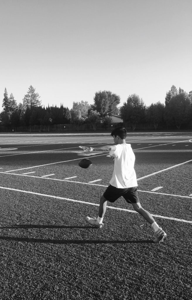 A picture of me kicking a football on a football field.