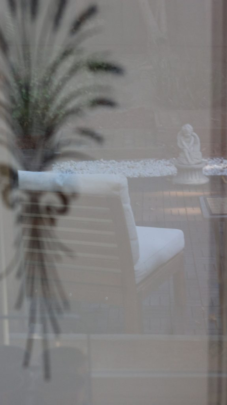 Image of frosted glass pantry door with reflection of outdoor chair in foreground