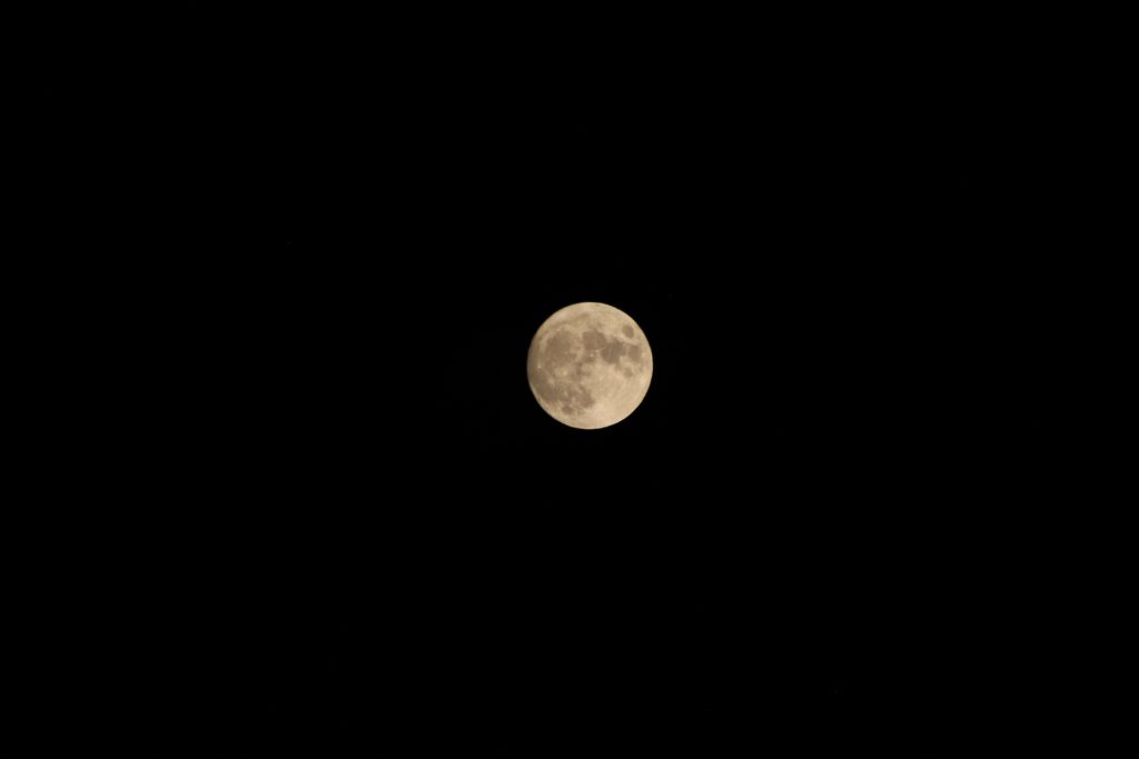 Full moon with a slight orange tint from the smoke in the air.