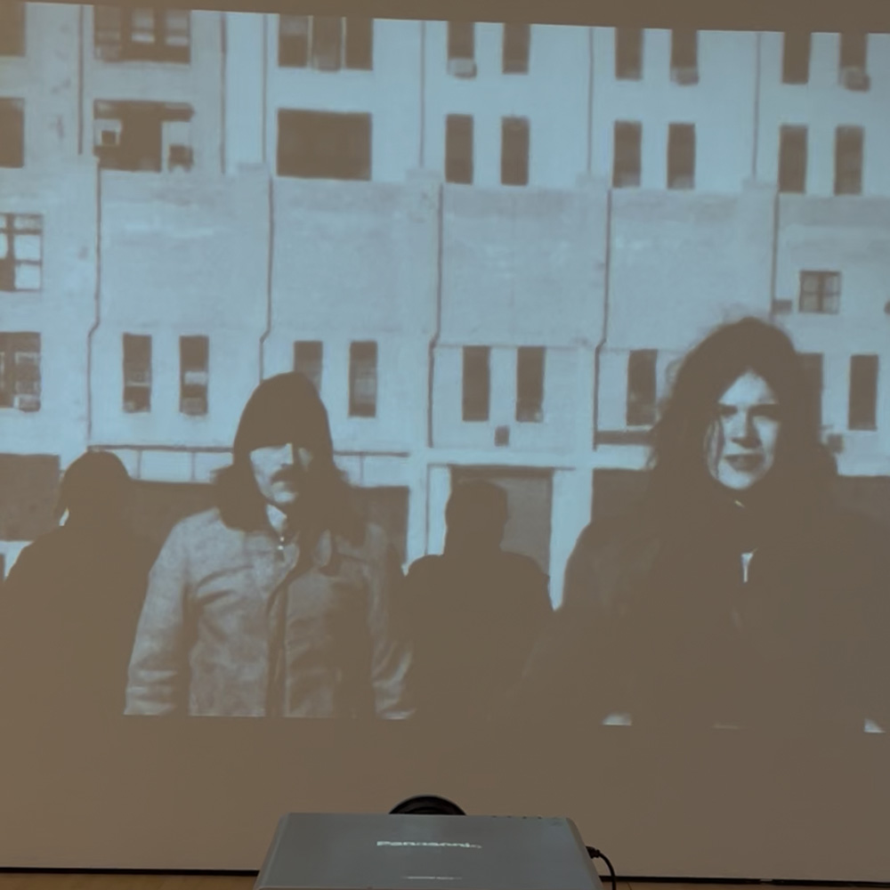 Projected Experimental Film of Actors in front of old building by the ocean