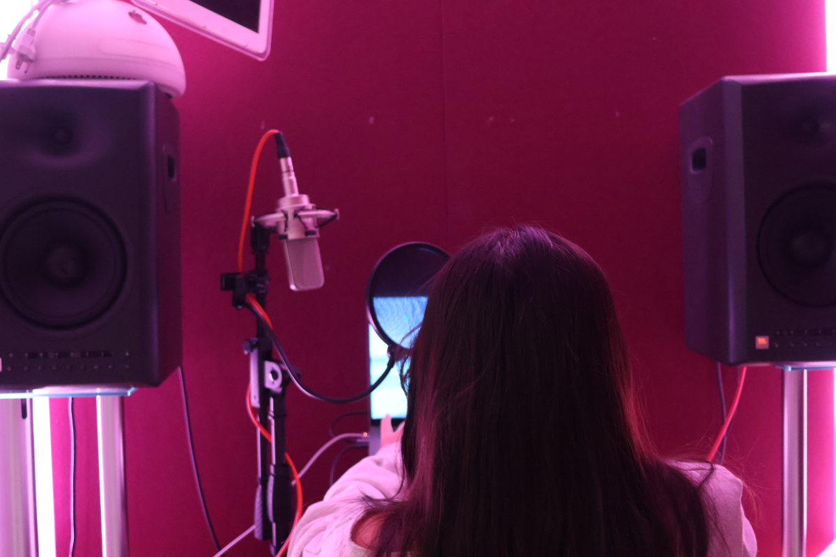 Me in recording booth, facing away from camera working on computer.