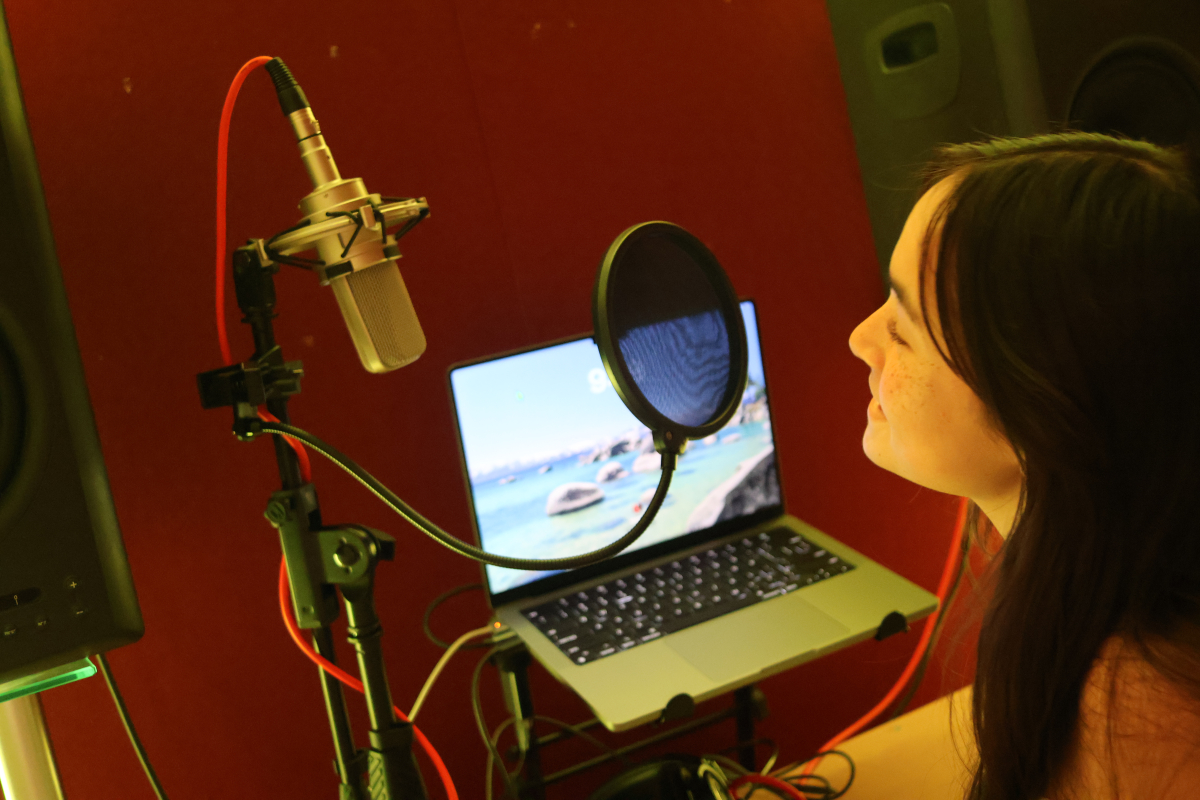 Me in recording booth singing into microphone.