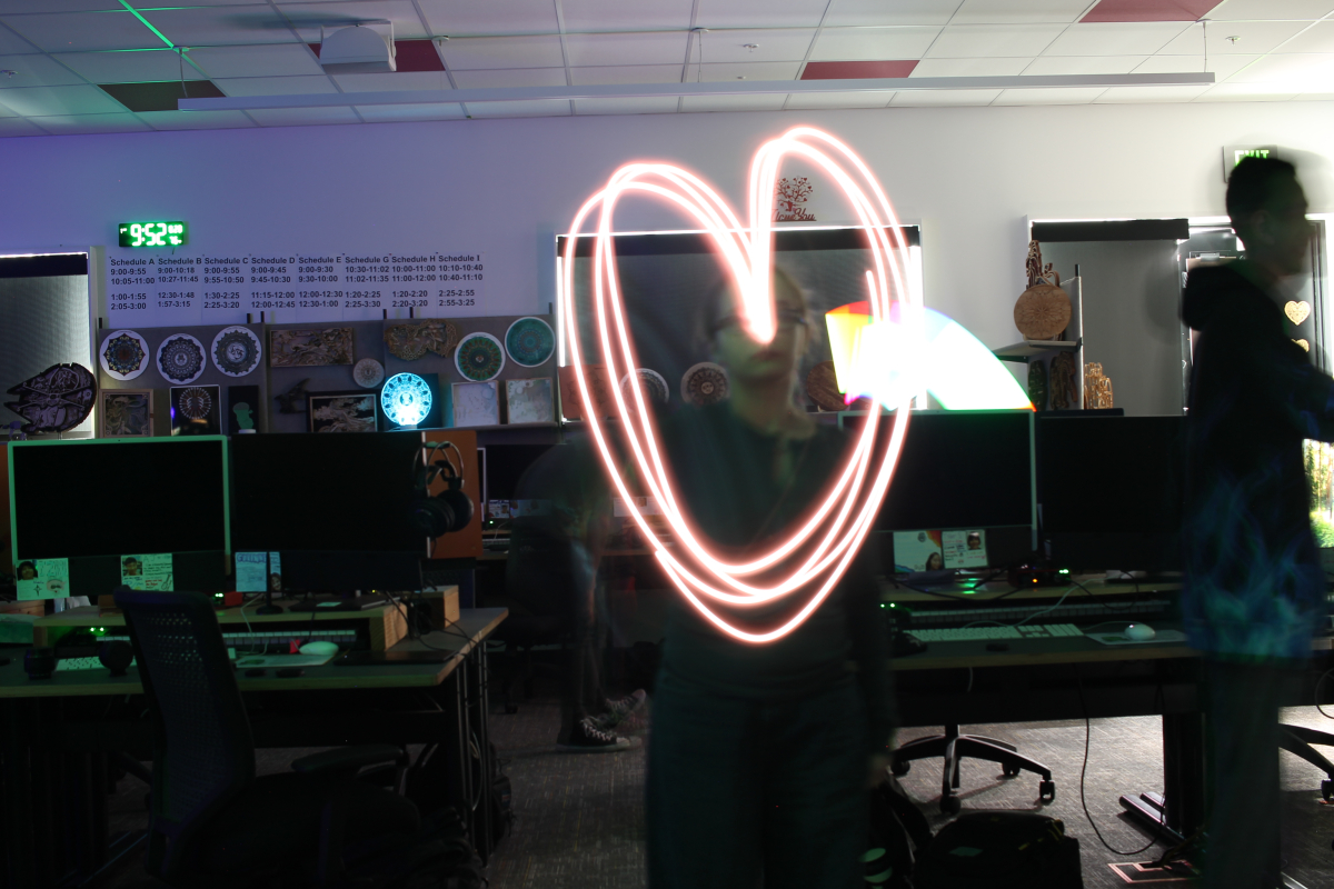 Long exposure picture of girl, Kayla, drawing out a heart with light.