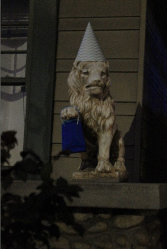 lion statue with a party hat and a goodie bag