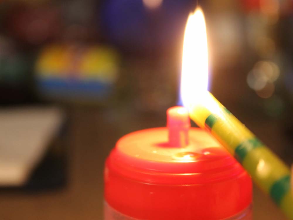 a candy bottle being melted by a flame brought to light by a birthday candle