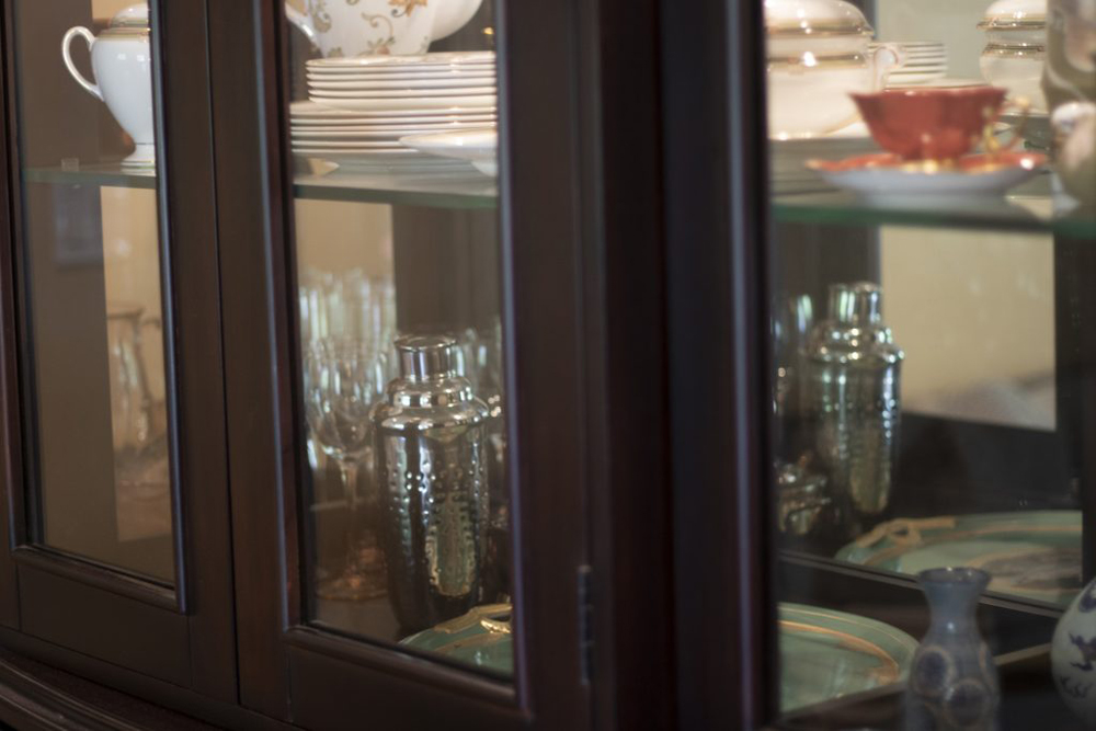 A cabinet with a mirrored back. It looks like there are doubles of the objects in the cabinet.