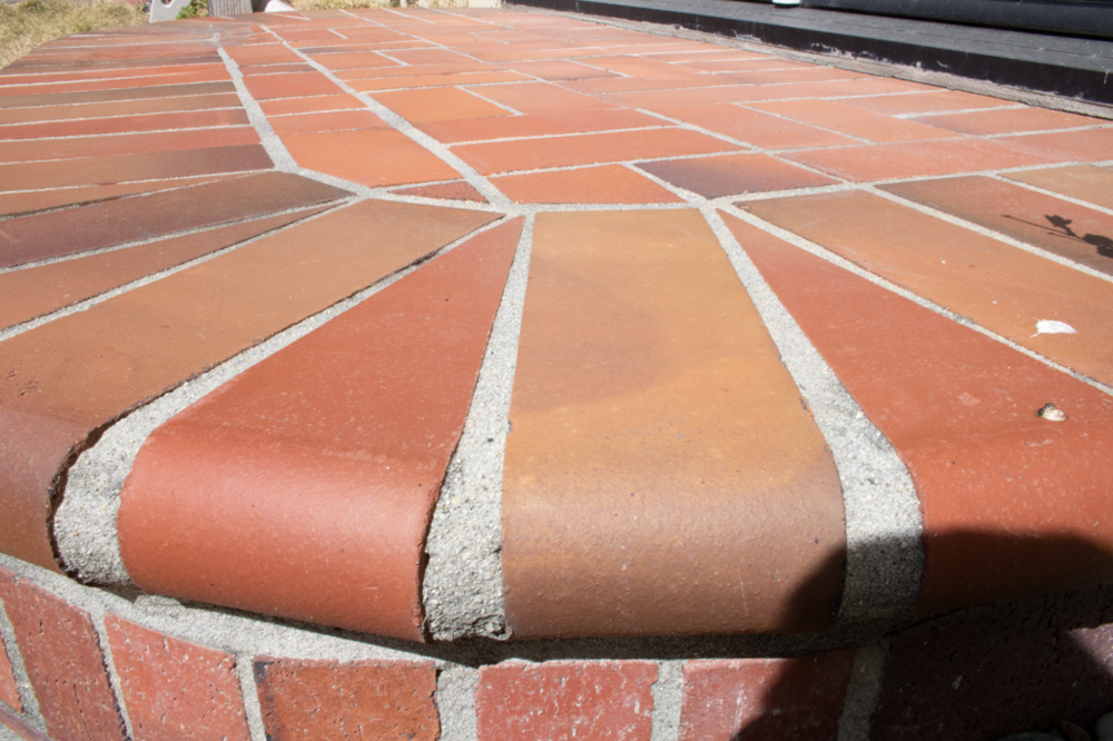 An image of a red brick patio. No one brick seems to be the center of attention.