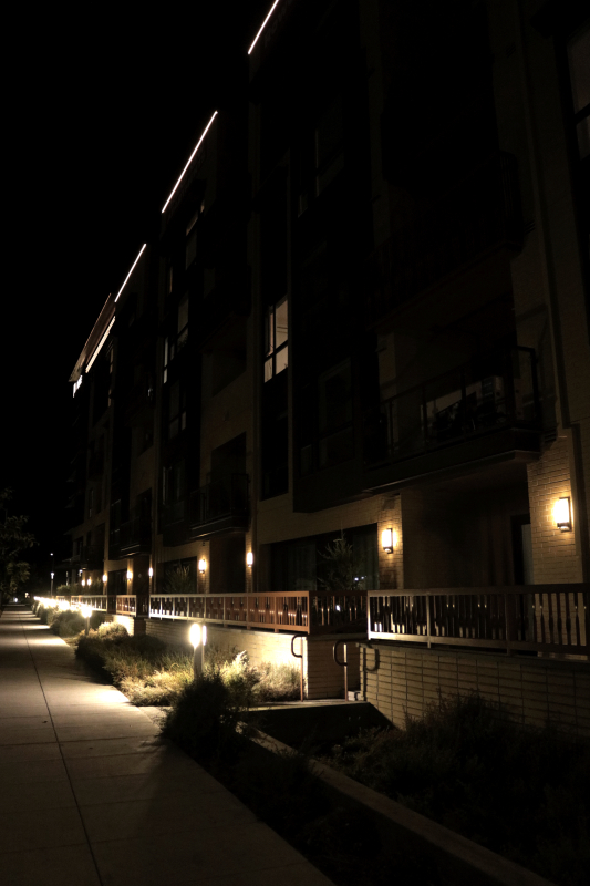 dark photo of a the side of a building with street lights