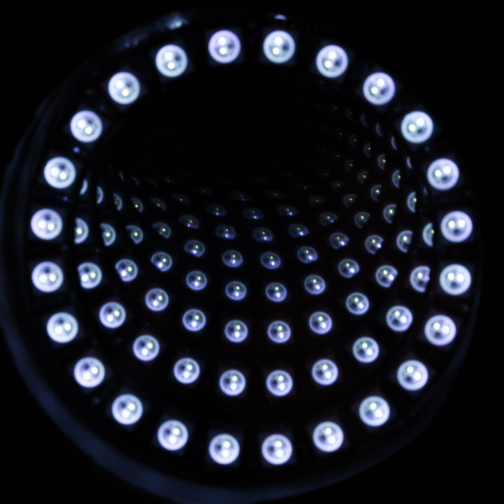 A photo of an infinity mirror. Small balls of light appear to vanish into the distance.
