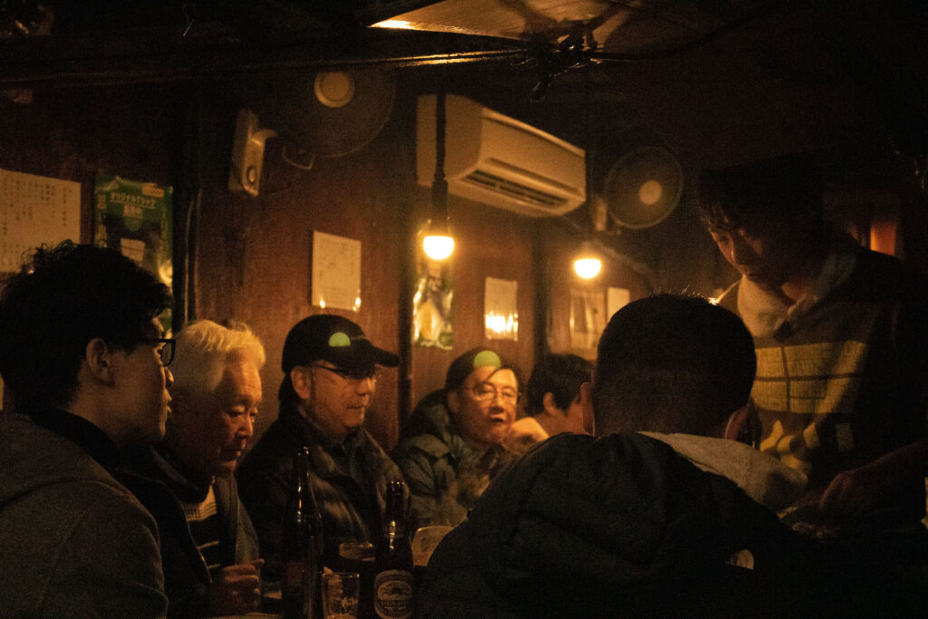A photo of some old men in a small, cramped bar. 