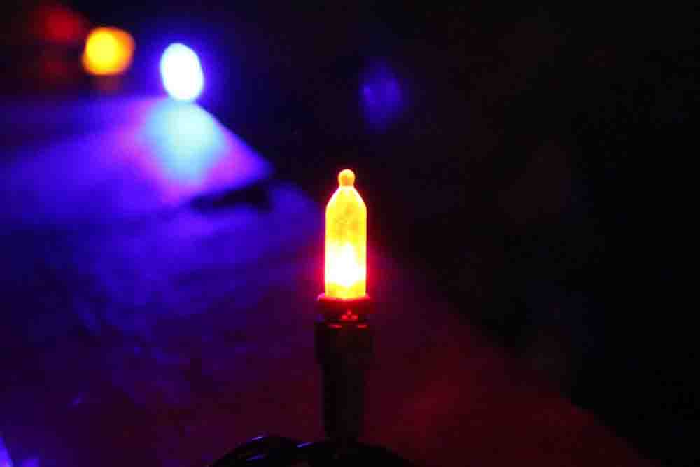A photo of an orange Christmas light.
