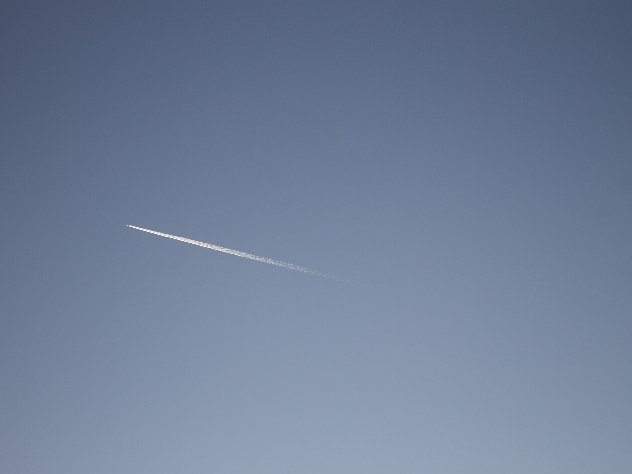 blue sky with an airplane jet fule tracks