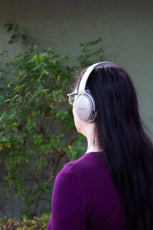 woman with headphones in front of nature background.