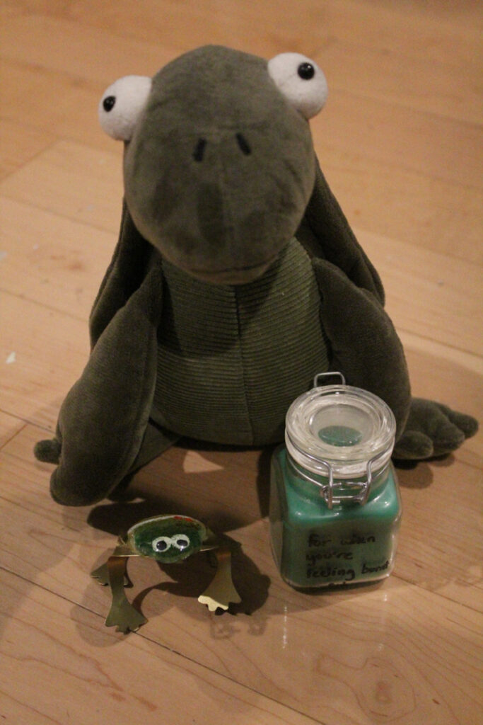 stuffed turtle, glass frog, and candle