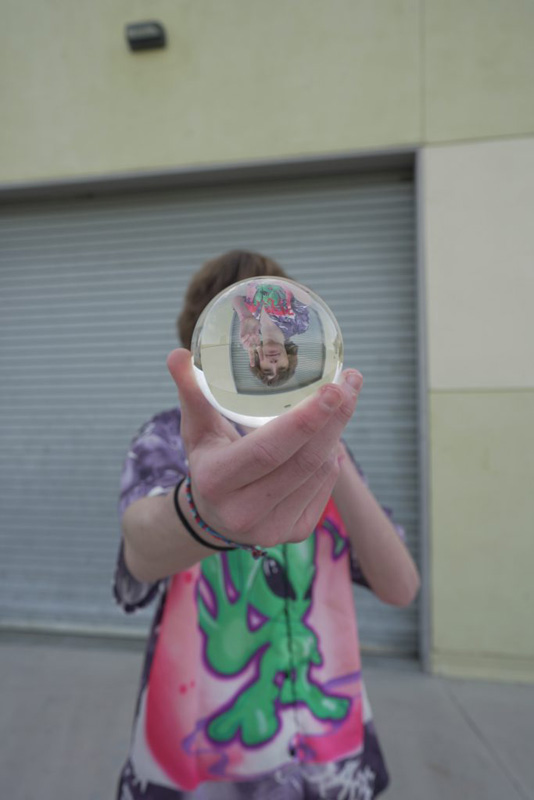 a photo of a man holding a crystal ball close to the camera.