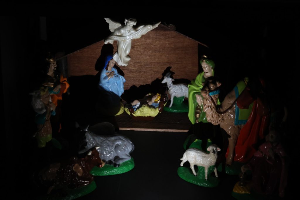 Nativity set with animals, shepards, an angel, and a baby in a manger.