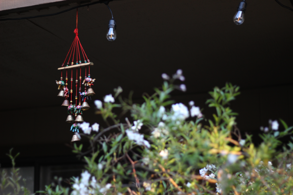 An image of a red decoration behind a bush.