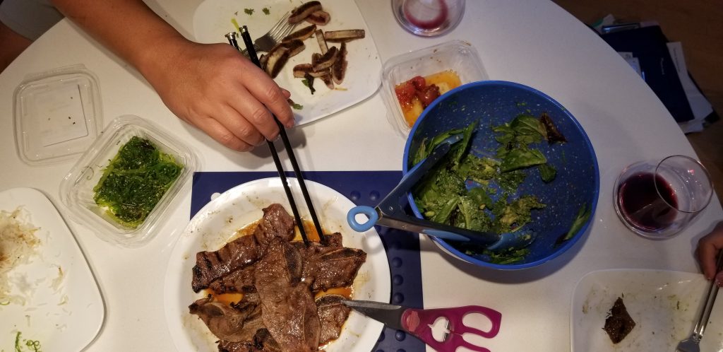 Photo that employs the Rule of Thirds. This photo shows my family having dinner, with vegetables and beef. My dad's hand is reaching for the ribs.