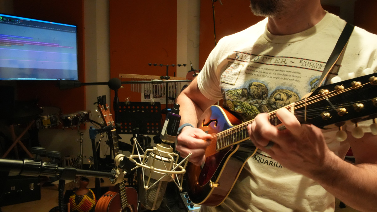 Close up of Brandon playing the Mandolin